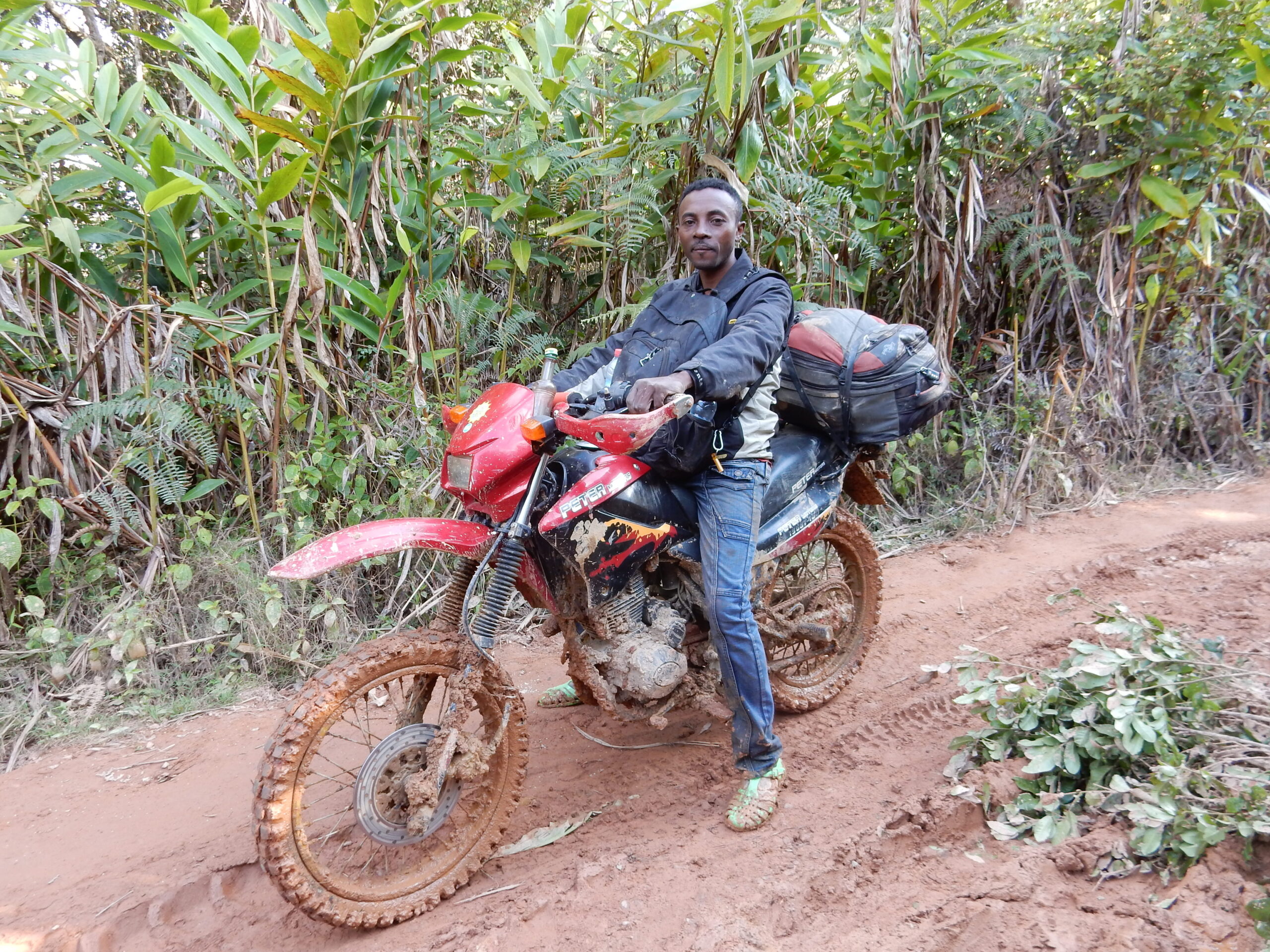 Rider on a lightweight motorcycle crossing remote Madagascar terrain