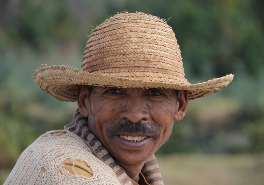 Antsirabe — smiling man wearing a straw hat