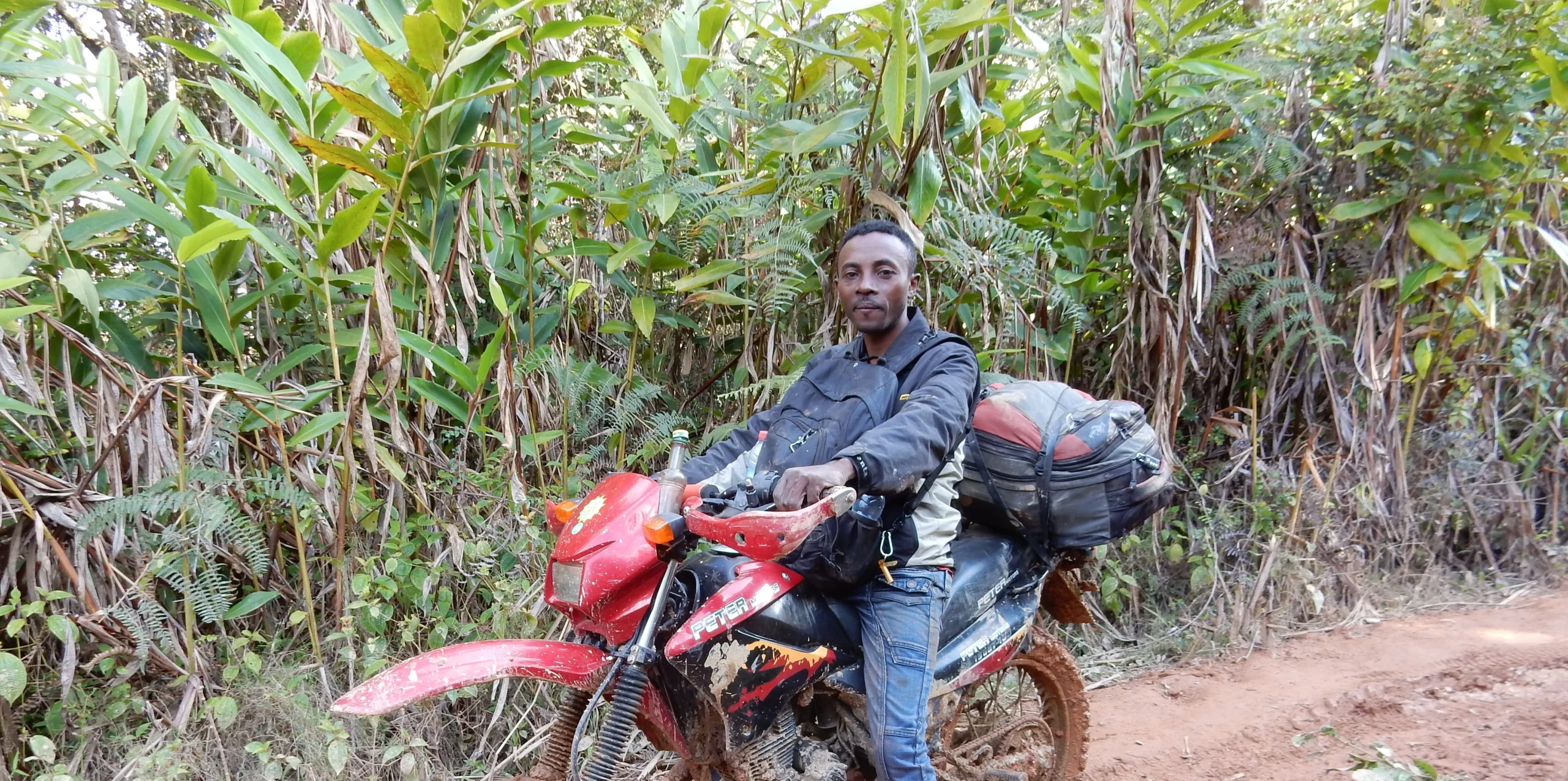 Rider on a lightweight motorcycle crossing remote Madagascar terrain